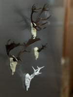 Deer magnet designs mounted on a metal surface; examples of finished and unfinished pieces.
